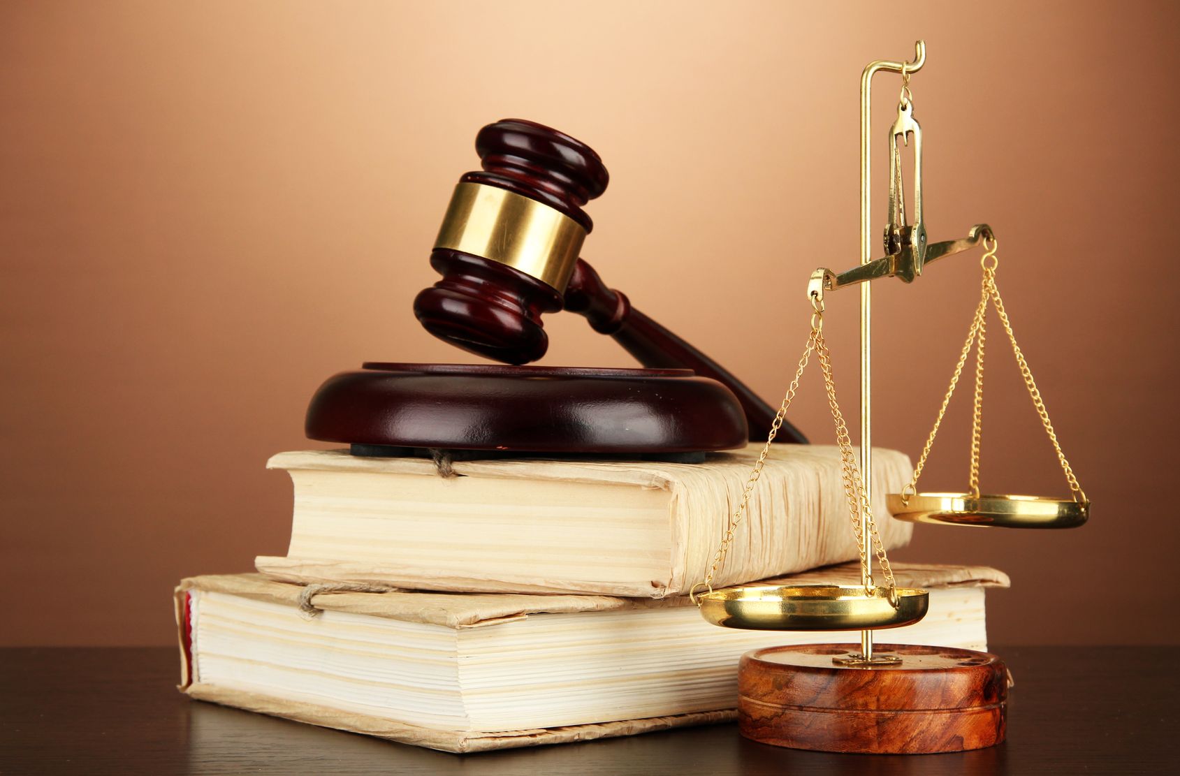 17037939 – golden scales of justice, gavel and books on brown background